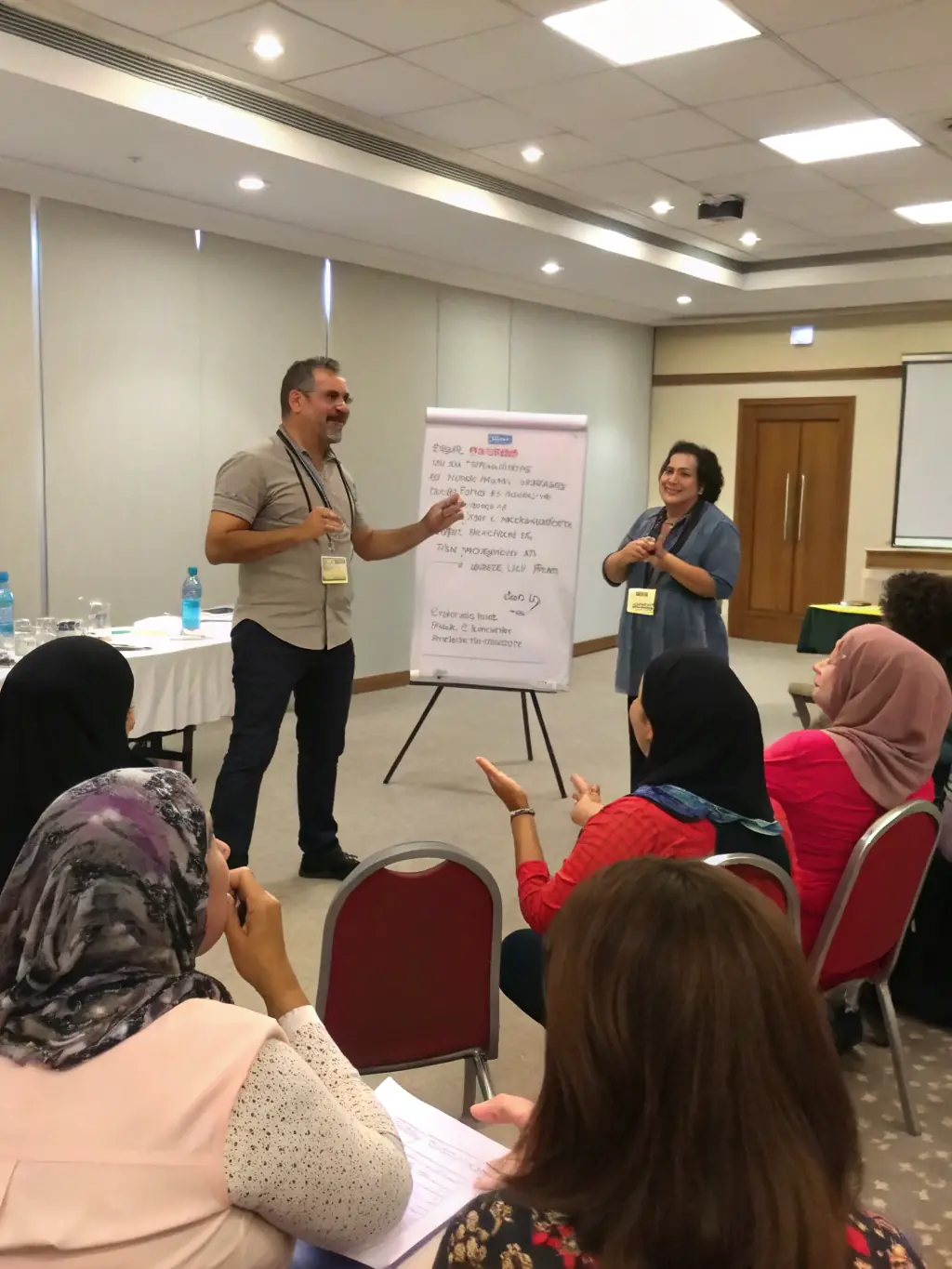 A South African business coach facilitating a workshop on effective communication and team building, with participants actively engaging in group exercises.